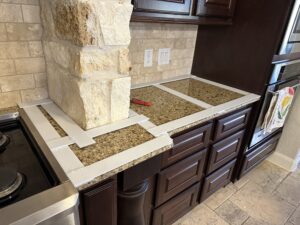 Earthtone granite countertop in kitchen with stone columns