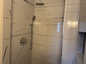 White large tiles after bathroom shower renovation